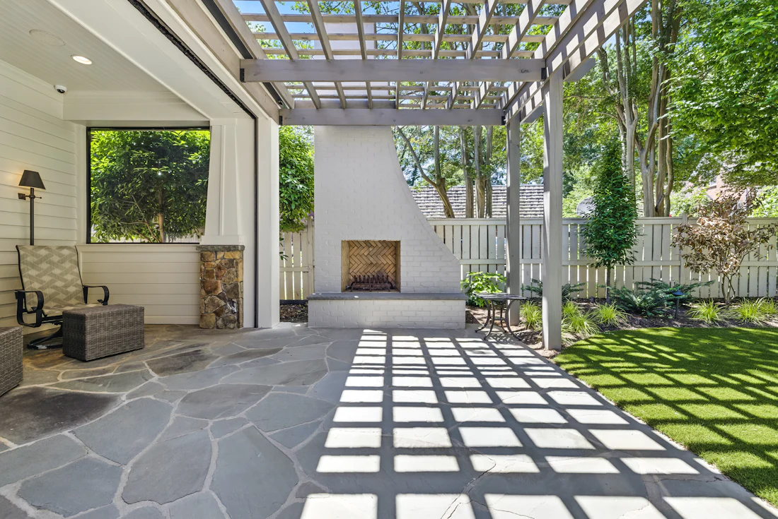 Paver patio with turf strips and pergola