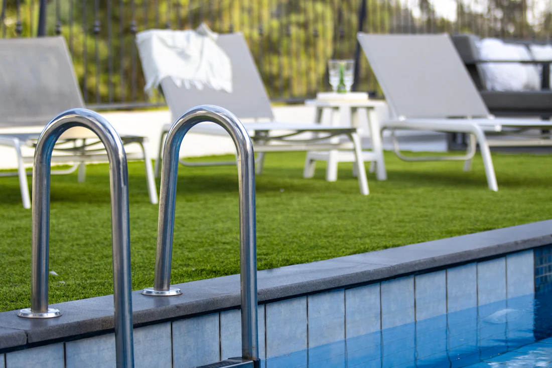Poolside turf lawn with lounge chairs