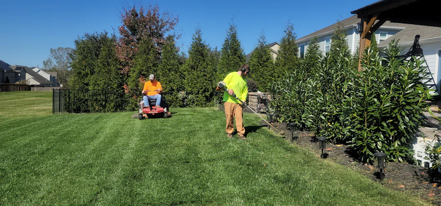Landscaper mowing a large green lawn